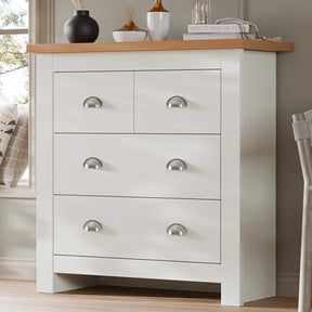[White] Shaker chest of drawers angled by bedroom window, oak top with vases, silver cup handles, white frame