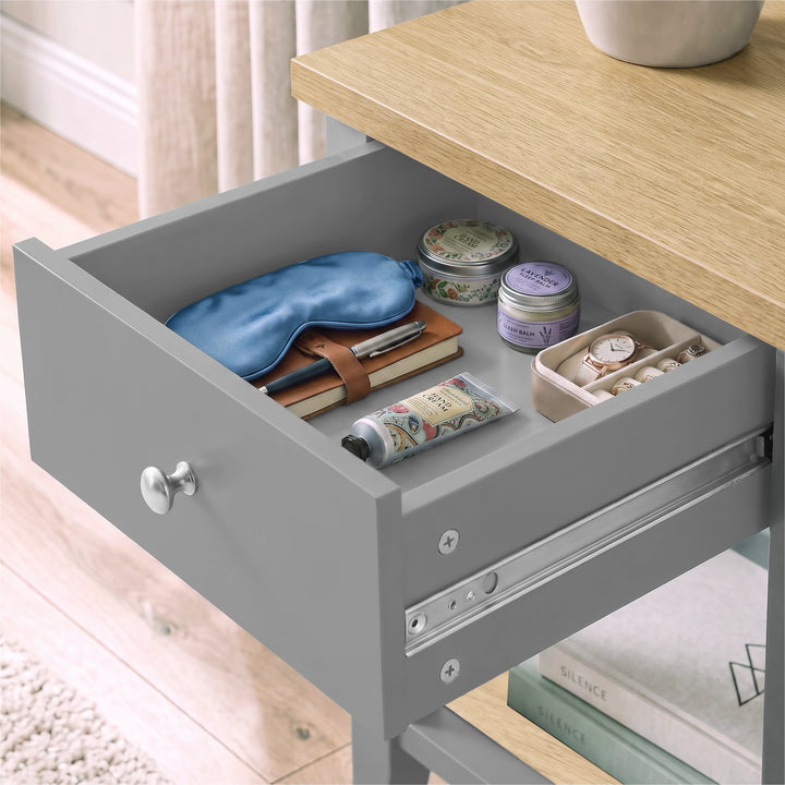 [Grey] Close-up of the open drawer holding an eye mask, books and small bedside essentials