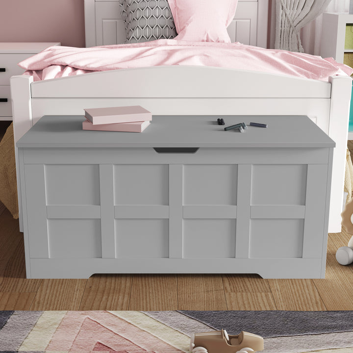 [Grey] Closed grey toy storage chest with grid panel front and central cutout handle in child's room