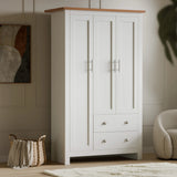 [White] White Shaker triple wardrobe beside woven basket, three panelled doors and two cup-handle drawers