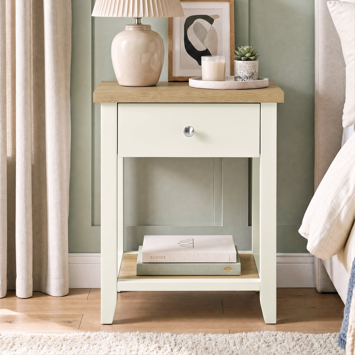 [White] Bedside lifestyle view with lamp on top, closed drawer and books on the lower shelf