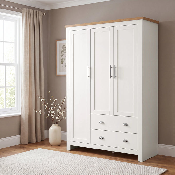 [White] White Shaker triple wardrobe beside woven basket, three panelled doors and two cup-handle drawers