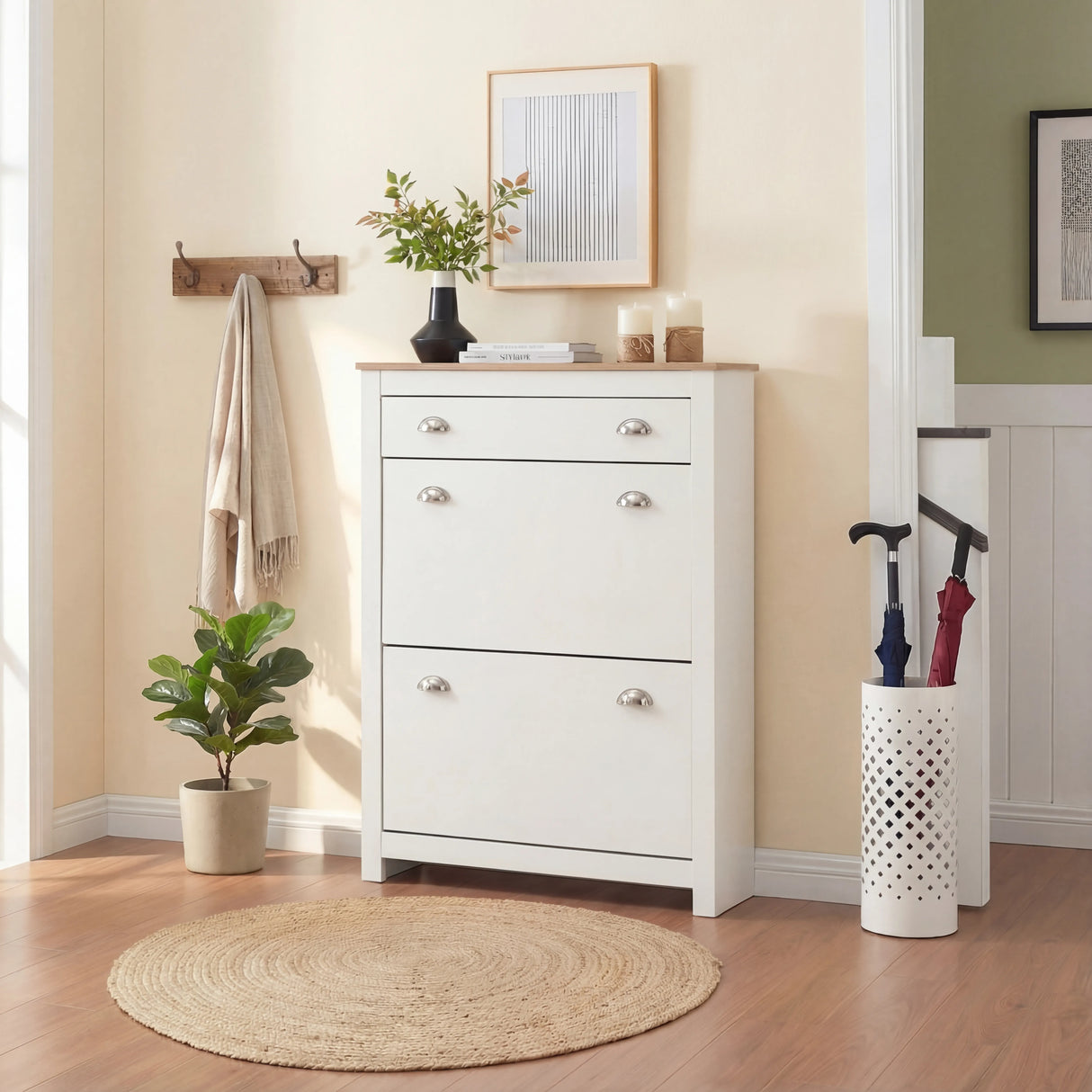 [White] White slim shoe cabinet closed front-on in hallway with framed art, coat hooks and umbrella stand