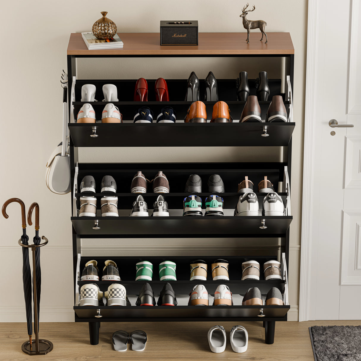 Three door shoe cabinet with doors in black oak top open, showing 24 shoes and music unit placed on top shelf area.
