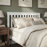 White single wooden bed frame with slatted headboard and cozy linens in a modern bedroom