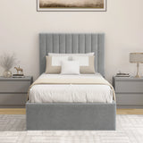 Grey upholstered bed with white bedding in a bedroom setting.