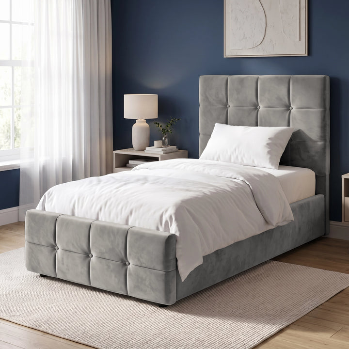 [Single | Grey] Angled bedroom view with square panel headboard, padded footboard, white bedding, lamp, and tall window