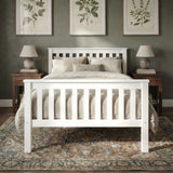 White single wooden bed frame with slatted pattern and soft bedding in a natural light bedroom