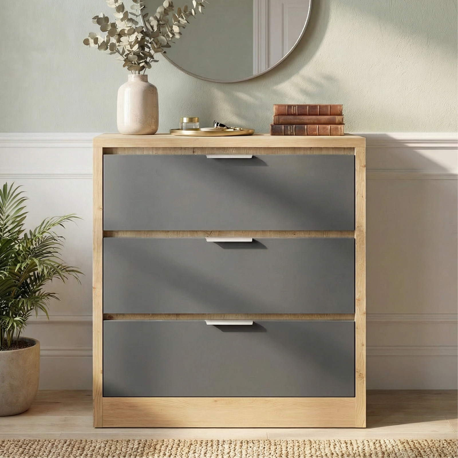 [Oak+Grey] Skova chest of drawers from the side, oak top with vase and round mirror behind on green wall