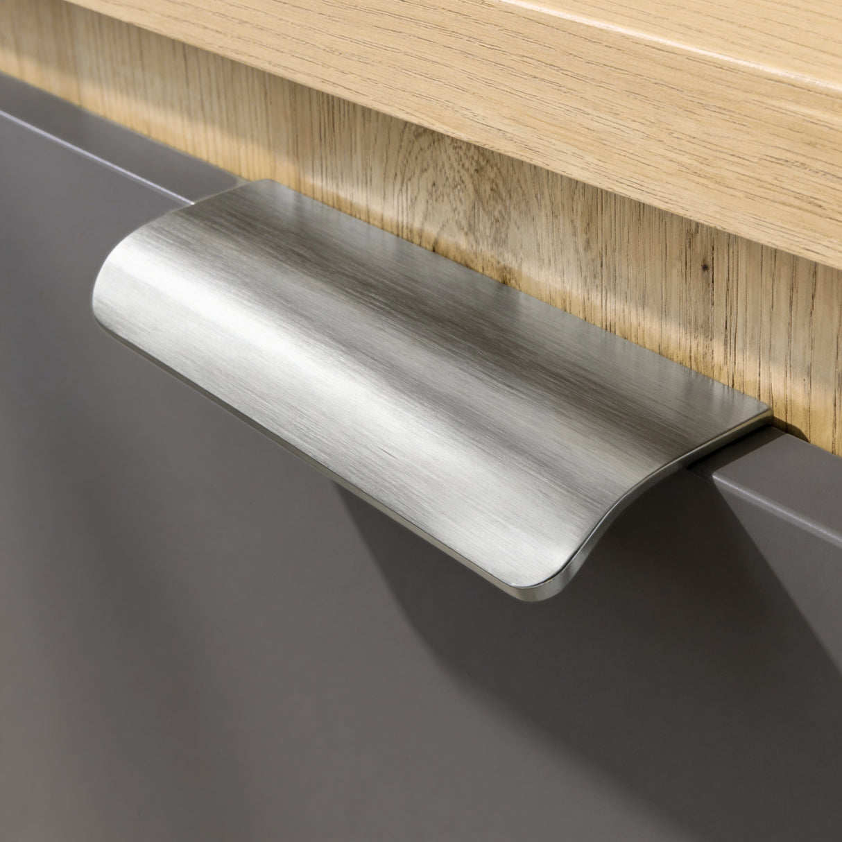 [Oak+Grey] Close-up of brushed metal cup handle on grey drawer of Skova chest of drawers against oak frame