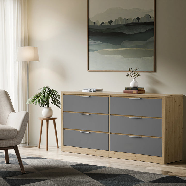 Wooden grey finish 6 drawer chest of bedroom drawers placed in a bright living space against a beige wall