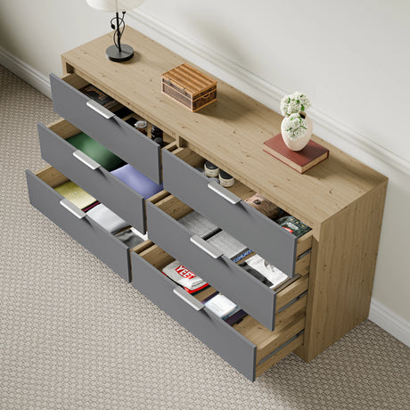 Skova 6 drawer chest of drawers in wooden grey finish with open drawers showing clothes and accessories in a bright room