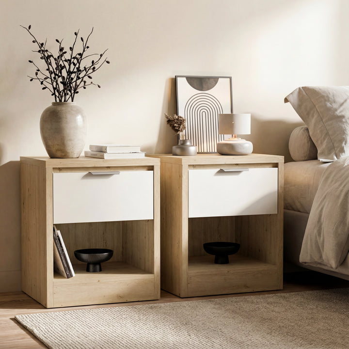 [Oak+White] Skova bedside pair in oak with white drawer fronts, vase and books on top, beside a bed in a neutral room