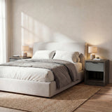 [Wooden Grey+Grey] Skova bedside pair flanking a cream upholstered bed, dark wooden grey tops with lit lamps