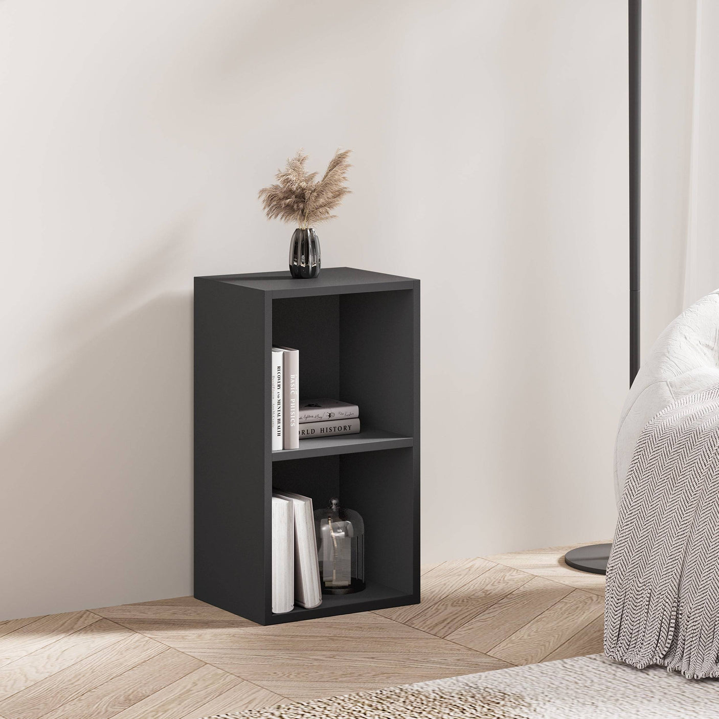 Black Blisswood narrow bookcase used as a bedside storage unit with books and decor.