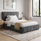 [Small Double | Grey] A modern gray upholstered bed with a tufted headboard and matching footboard, styled in a bright bedroom with white bedding, a beige throw blanket, light wood nightstands, and a patterned rug.
