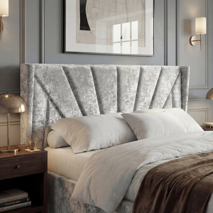[Small Double | Silver] Close view of Sunrise wing headboard with pleated panels, pillows, and brass bedside lamp