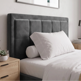 [Small Double | Grey] bed with a grey tufted upholstered headboard, dressed in white bedding with a white pillow and cylindrical bolster pillow, styled in a minimalist bedroom setting.
