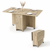 [Sonoma Oak] Space saving folding dining table for four shown fully opened & shown compact with both leaves folded on wheels.
