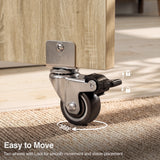 [Sonoma Oak] Dining table with wheels close-up view showing a 360-degree swivel caster and foot-operated locking brake pedal.