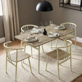 [Sonoma Oak] Torvi dining scene with four place settings, cream chairs, a textured rug, and a black pendant light.