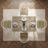 [Sonoma Oak] Torvi overhead view showing four chairs, plates, tied napkins, glasses, and a vase on a textured rug.