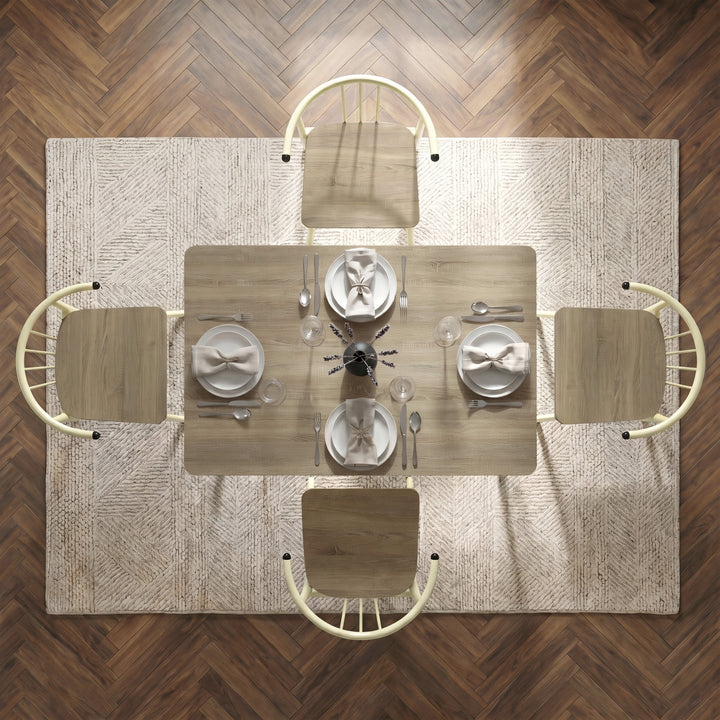 [Sonoma Oak] Torvi overhead view showing four chairs, plates, tied napkins, glasses, and a vase on a textured rug.