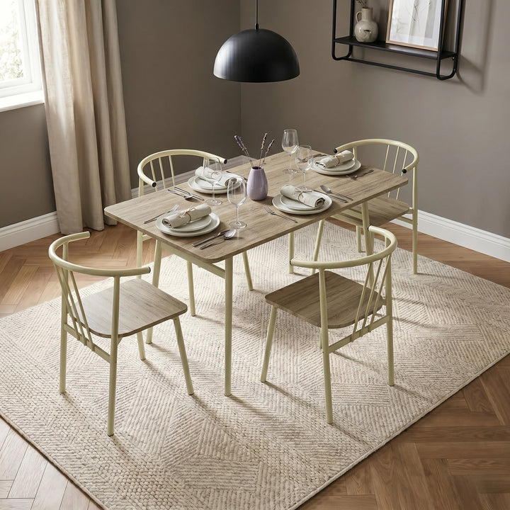 [Sonoma Oak] Torvi dining table and four cream metal armchairs with curved backs, styled with place settings and a lavender vase centrepiece