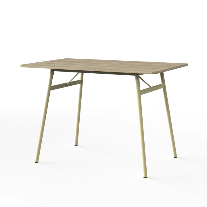[Sonoma Oak] Torvi dining table alone on white background showing oak-effect MDF top and cream metal angled legs with cross-brace frame detail