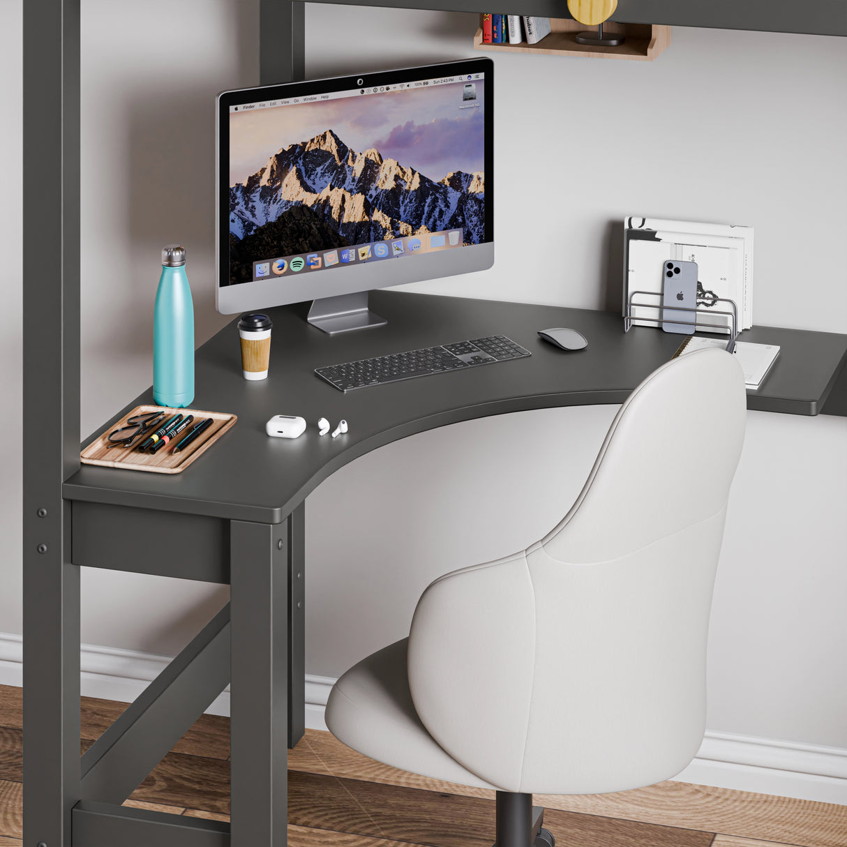 Space-saving corner workstation with neatly organised computer setup and a grey chair under the dark grey bunk bed