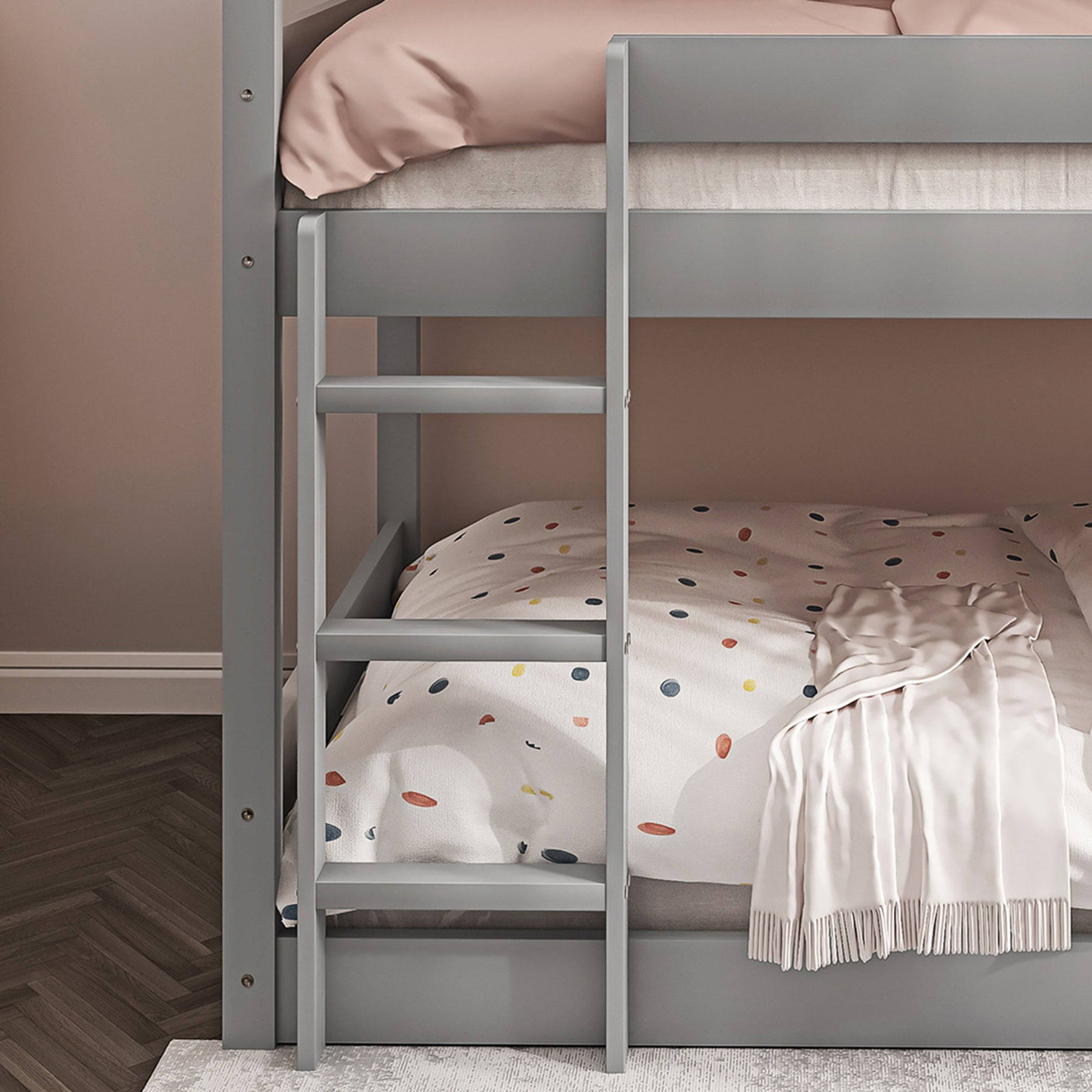Close-up of lower ladder on grey triple bunk bed, showcasing child-friendly access and sturdy build.