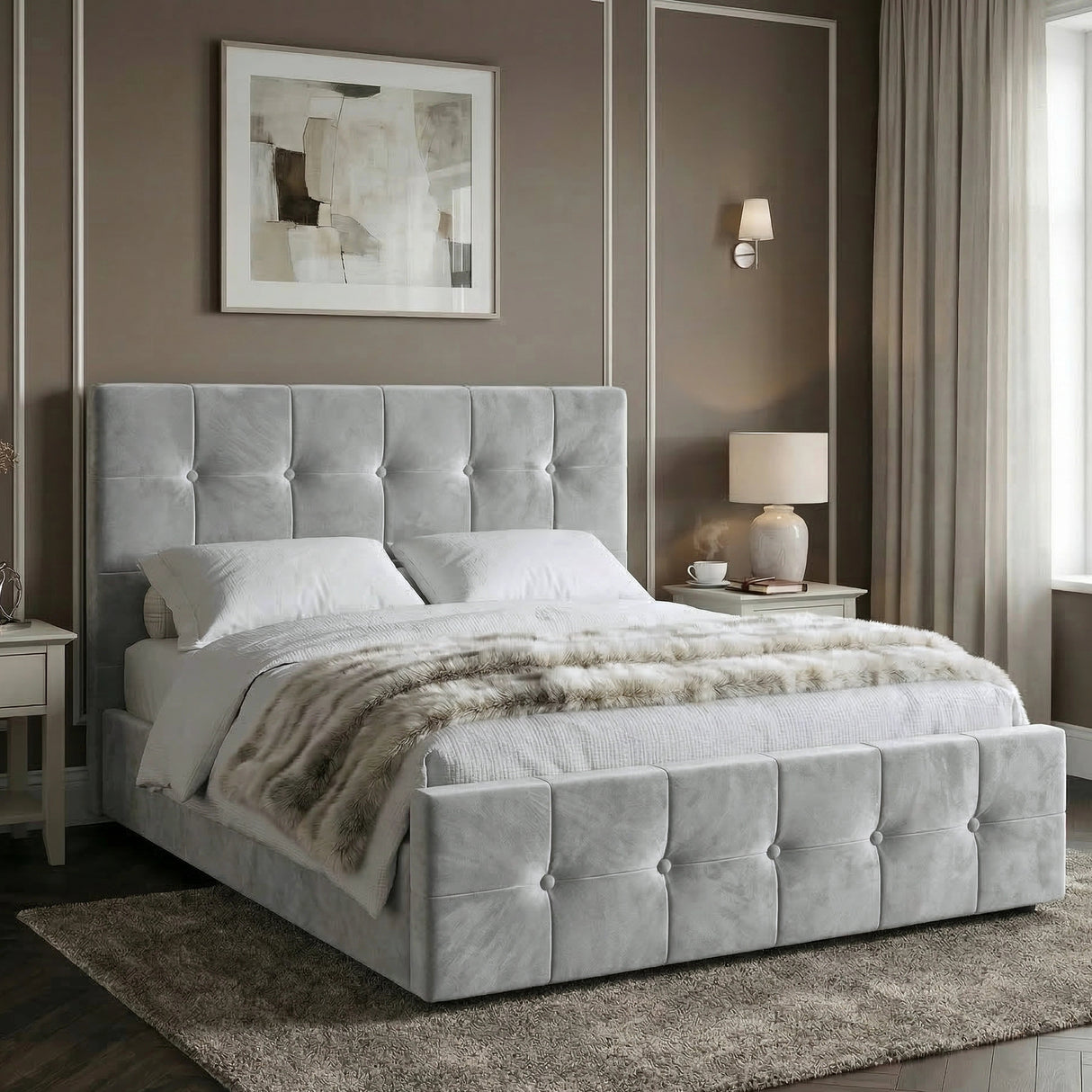 [Double | Grey] Side angle of tufted ottoman bed against taupe wall with white panel moulding and brass wall sconce glowing