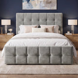 [Double | Grey] Front view of tufted ottoman bed centred between grey nightstands with brass wall sconces and abstract art