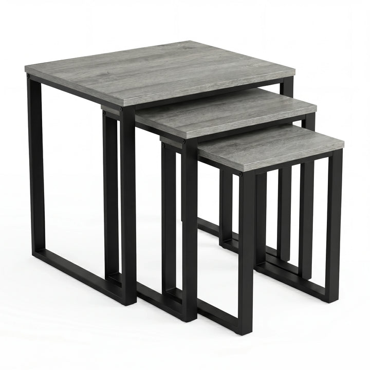 [Grey Wooden] Stackora set of 3 nesting tables angled view in a living room with sofa and accessories on grey tops