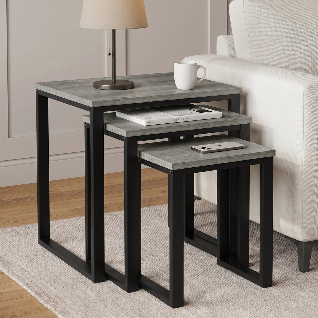 [Grey] Stackora set of 3 nesting tables in a living room beside a sofa with vase and books on grey top
