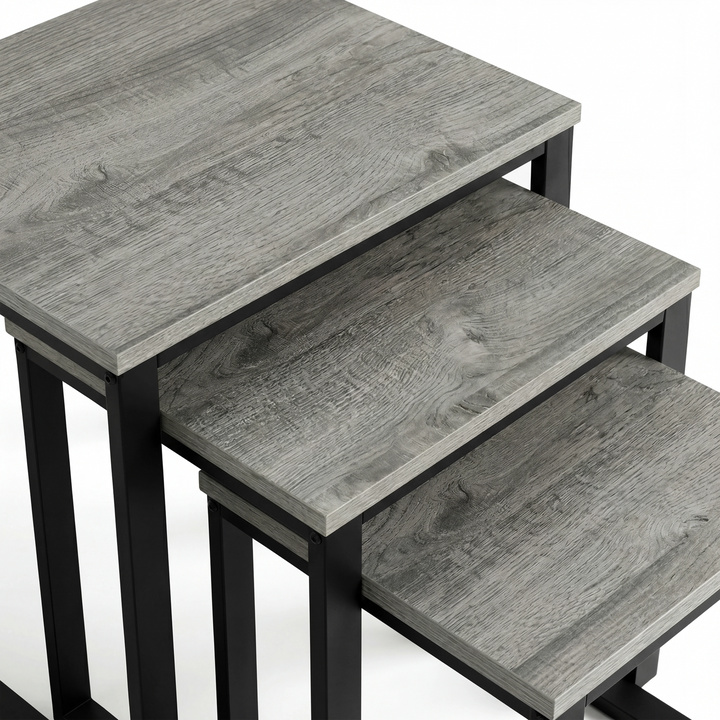[Grey Wooden] Stackora nesting tables separated in a living room beside sofa with vase and plant on grey effect tops
