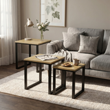 [Oak] Stackora nesting tables separated in a living room beside sofa with vase and plant on oak effect tops