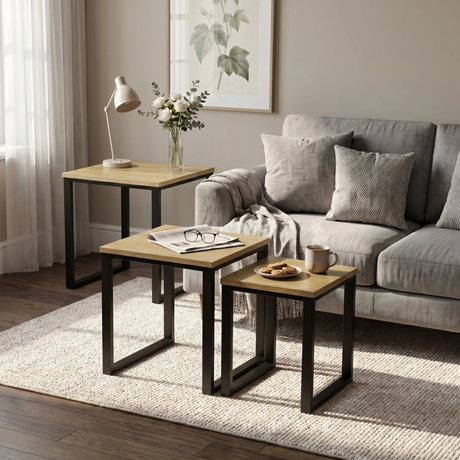 [Oak] Stackora nesting tables separated in a living room beside sofa with vase and plant on oak effect tops