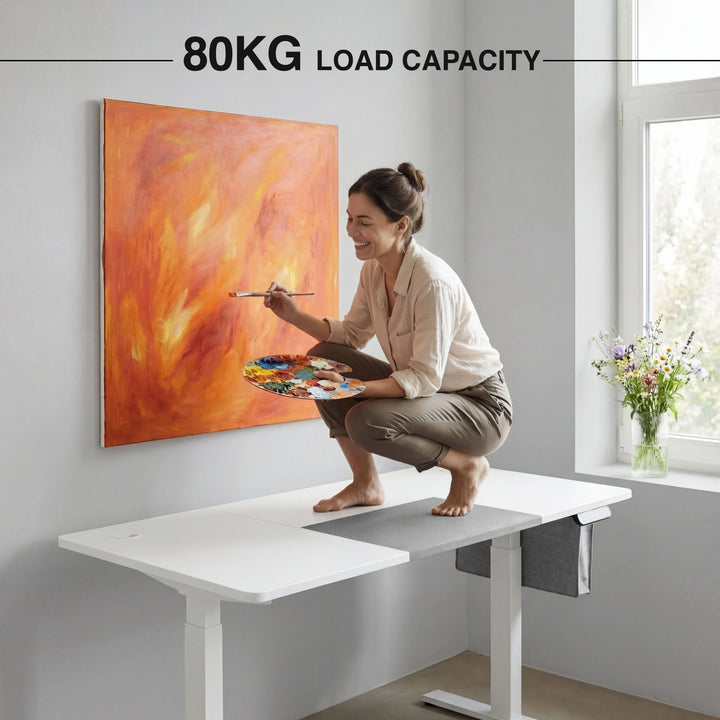 [140cm x 60cm] Load demo on 140x60cm white electric standing desk: woman crouching on top painting canvas, 80kg cap