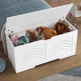 Storage Chest - Wooden Box With Lid For Blankets, Clothes or Toys in white finish, open and filled with plush toys beside a bed in a kids' room.