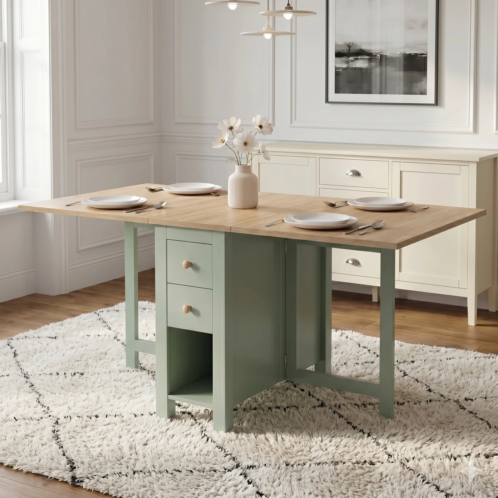 [Green] Stovra Drop Leaf Dining Table with Storage 150cm fully extended into a four-person setup with white plates, a central flower vase, and drawers 