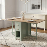 [Green] Stovra Drop Leaf Dining Table with Storage fully extended into a four-person setup with white plates, a central flower vase, and built-in side drawers