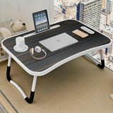 Portable tables laptop with tablet slot, cup holder, and sleek striped wooden surface.