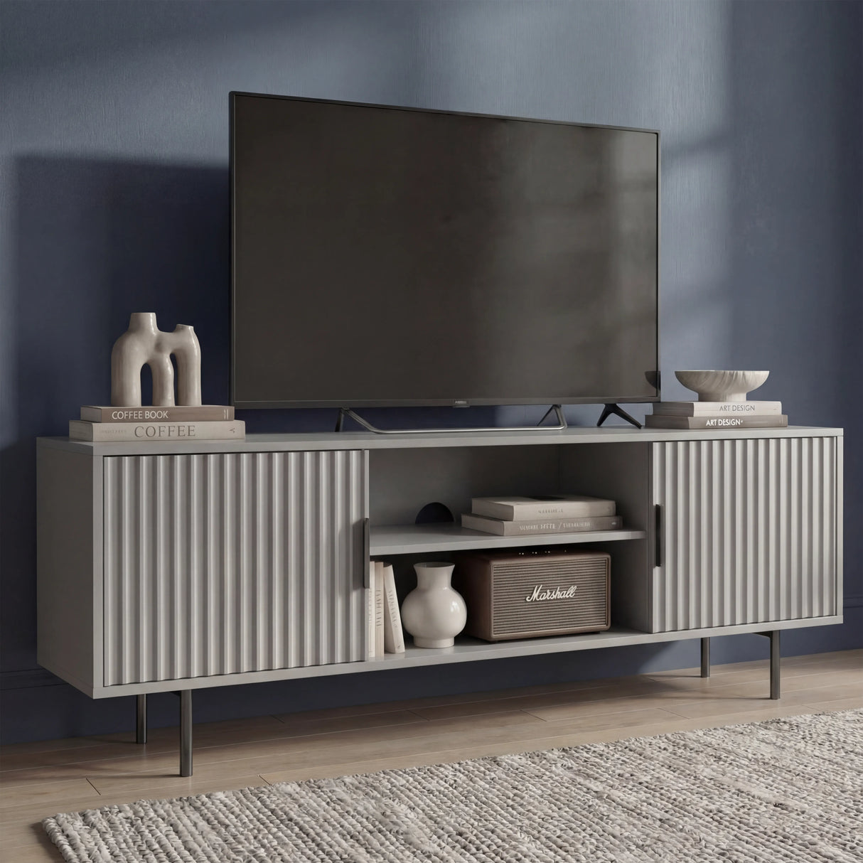 Tall grey TV entertainment stand with vertical fluted panels and slim silver legs for a modern, elevated home look.