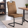 [Tan] High-back metal dining chair beside a wood table, showing upholstery, carry grip and black loop frame.