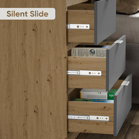 Close-up of three partially open bedroom chest of drawers in grey and oak finish, showing the smooth metal drawer hardware