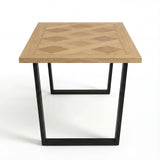 Side view of Aldridge dining table, showcasing the intricate parquet wood design and sleek black metal legs.