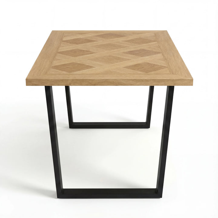 [4 Seater | Grey] Aldridge oak dining table seen from the end-corner with diamond parquet detail above the black sled leg.