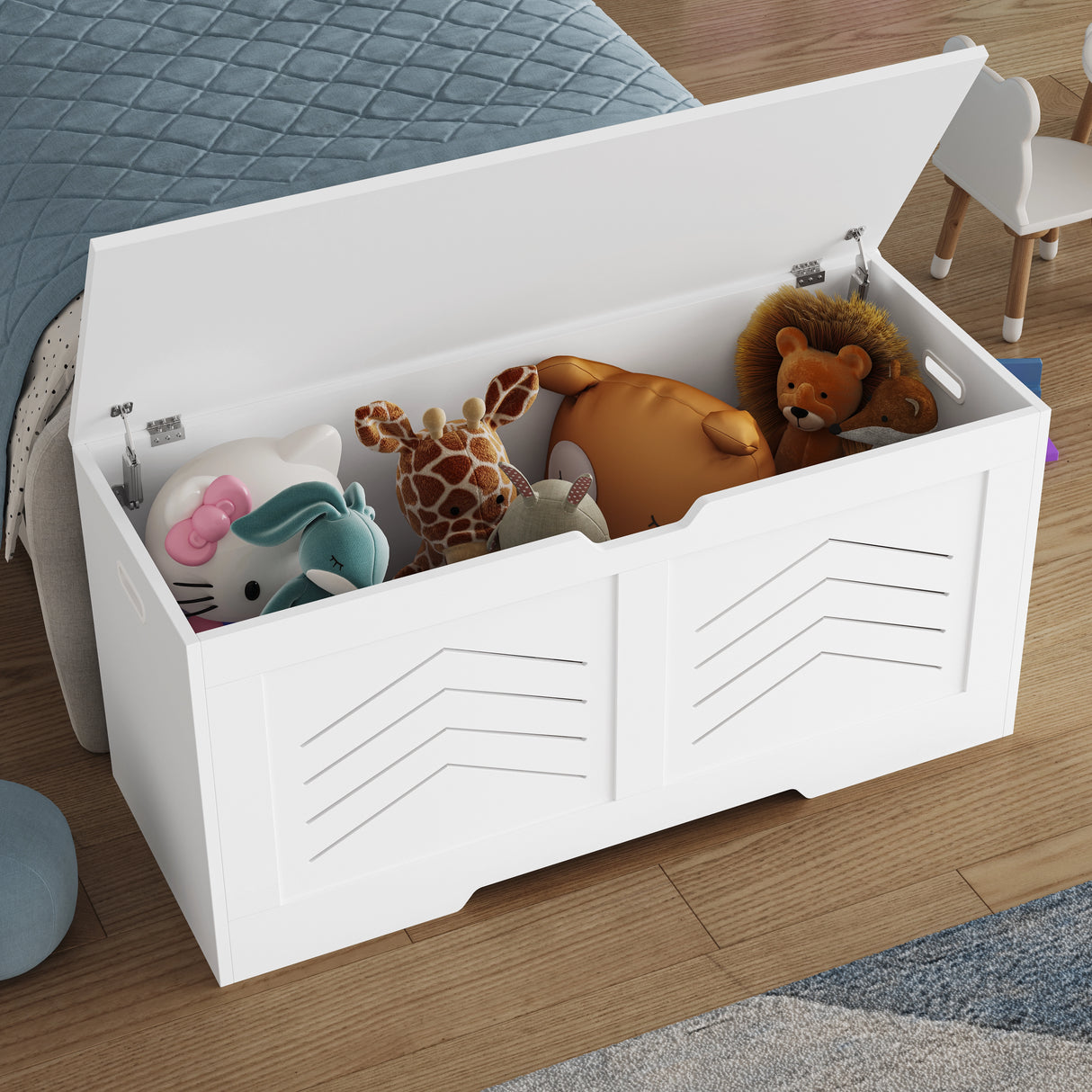Storage chest - wooden box with lid for blankets, clothes or toys in white finish, shown open and filled with plush toys beside a bed.