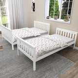 White wooden bunk beds separated into two single beds, showcasing convertible design of triple bunk bed for kids.